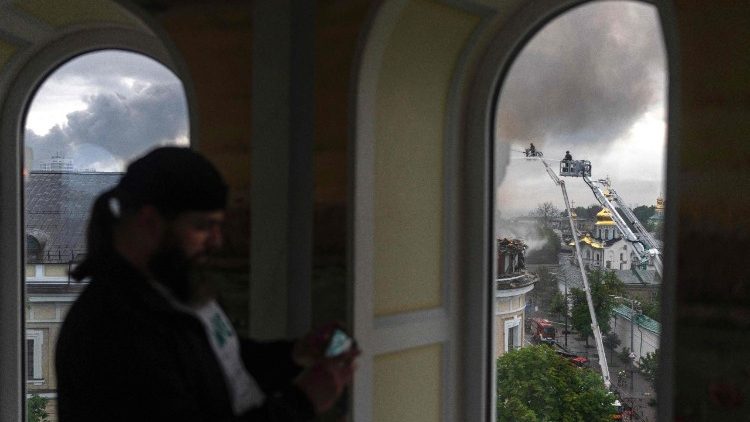 Um padre ortodoxo (em primeiro plano) usa seu telefone enquanto bombeiros (ao fundo) trabalham para controlar um inc&ecirc;ndio no Complexo do Museu Nacional de Arte e Cultura do Arsenal de Mystetskyi, a principal institui&ccedil;&atilde;o cultural p&uacute;blica da Ucr&acirc;nia, ap&oacute;s um ataque de m&iacute;sseis russos em Kiev, em 15 de junho de 2026, em meio &agrave; invas&atilde;o russa da Ucr&acirc;nia. A R&uacute;ssia disparou uma s&eacute;rie de m&iacute;sseis contra v&aacute;rias das principais cidades ucranianas, incendiando a hist&oacute;rica Catedral da Dormi&ccedil;&atilde;o de Kiev e matando nove pessoas, enquanto ataques na Ucr&acirc;nia causaram tr&ecirc;s mortes ao sul de Moscou. (Foto de OLEKSII FILIPPOV / AFP)