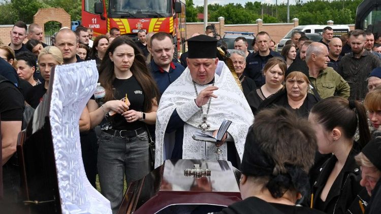 Familiares, amigos e colegas lamentam junto aos caix&otilde;es dos bombeiros ucranianos Danylo Tishchenko, Vadym Zinchenko e Oleksiy Dorozhkin, mortos em um ataque russo, durante uma cerim&ocirc;nia f&uacute;nebre em um cemit&eacute;rio em Kharkiv, em 17 de junho de 2026, em meio &agrave; invas&atilde;o russa da Ucr&acirc;nia. (Foto de SERGEY BOBOK / AFP)