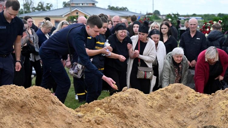 Familiares, amigos e colegas lamentam junto aos caix&otilde;es dos bombeiros ucranianos Danylo Tishchenko, Vadym Zinchenko e Oleksiy Dorozhkin, mortos em um ataque russo, durante uma cerim&ocirc;nia f&uacute;nebre em um cemit&eacute;rio em Kharkiv, em 17 de junho de 2026, em meio &agrave; invas&atilde;o russa da Ucr&acirc;nia. (Foto de SERGEY BOBOK / AFP)