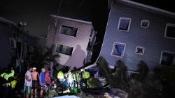 Moradores e equipes de emergência observam os prédios danificados após um terremoto em Catia La Mar, a cerca de 30 km a noroeste de Caracas, na madrugada de 25 de junho de 2026. Dois fortes terremotos gêmeos mataram 32 pessoas e feriram mais de 700, informou o presidente interino do país em 25 de junho, após os tremores massivos terem derrubado prédios inteiros e causado pânico na população. (Foto de Federico Parra / AFP)