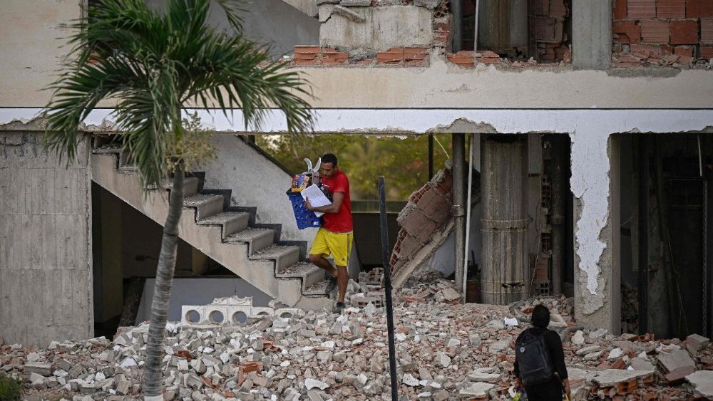 Um homem carrega pertences para fora de um prédio danificado após um terremoto em Catia La Mar, estado de La Guaira, a cerca de 30 km a noroeste de Caracas, em 25 de junho de 2026. (Foto de Federico Parra / AFP)
