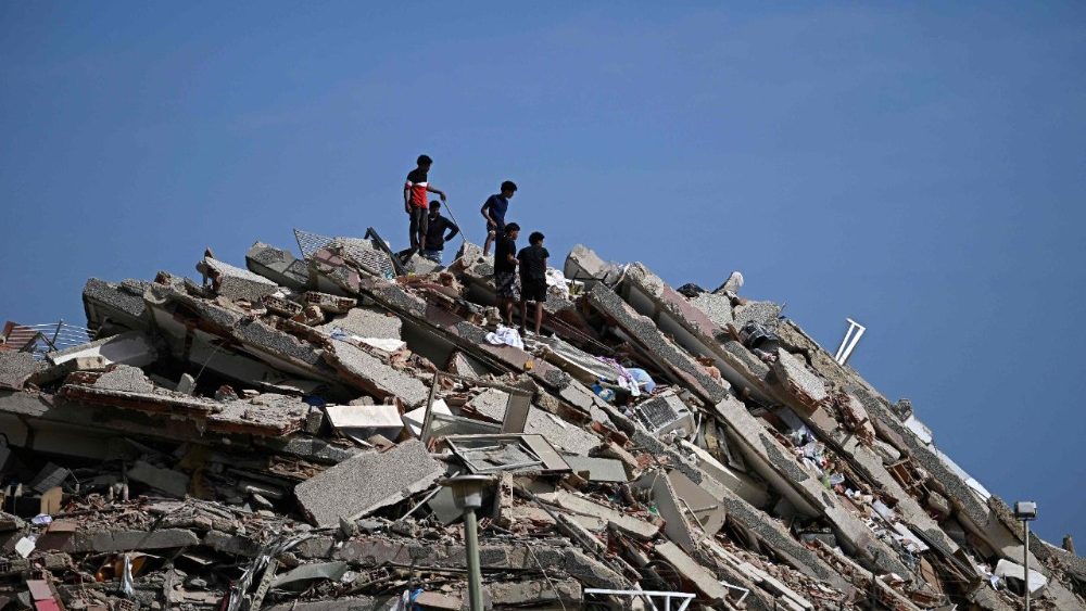 Pessoas procuram sobreviventes enquanto outras tentam salvar pertences em um prédio que desabou após um terremoto em Catia La Mar, estado de La Guaira, a cerca de 30 km a noroeste de Caracas, em 25 de junho de 2026. (Foto de Federico Parra / AFP)