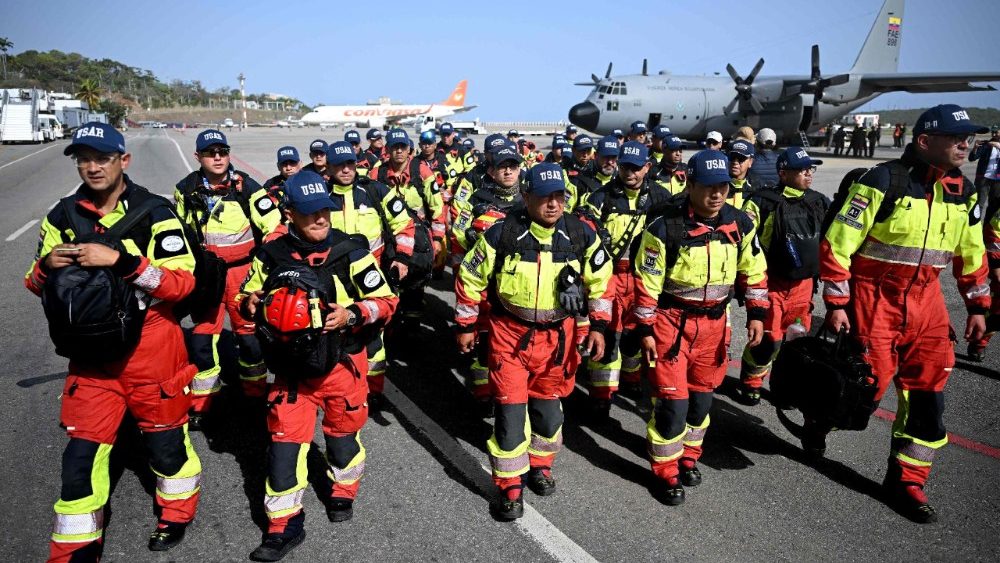 Bombeiros equatorianos da equipe de Busca e Resgate Urbano (USAR) caminham na pista ao chegarem ao Aeroporto Internacional Simón Bolívar, em La Guaira, Venezuela, em 26 de junho de 2026, após os terremotos devastadores. Usando equipamentos pesados ​​ou as próprias mãos, socorristas e voluntários buscaram sobreviventes do terremoto duplo na Venezuela, que deixou oficialmente 589 mortos e, segundo estimativas, milhares de desaparecidos. (Foto de Federico Parra / AFP)