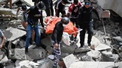Miembros y voluntarios de Protección Civil de Venezuela recuperan un cadáver en el lugar donde se derrumbaron varios edificios tras los terremotos ocurridos en Caraballeda, en el estado de La Guaira (Venezuela)