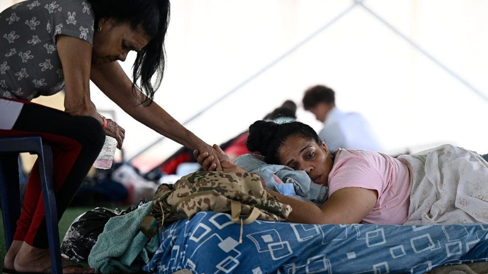 Moradores desabrigados após os terremotos gêmeos de 24 de junho descansam em um acampamento improvisado no complexo esportivo José María Vargas, em Maiquetia, estado de La Guaira, Venezuela, em 30 de junho de 2026. Dezenas de milhares de pessoas precisam urgentemente de comida e abrigo na Venezuela devido à devastação causada pelos dois grandes terremotos que mataram mais de 1.700 e feriram 5.000, informou a ONU em 30 de junho de 2026, enquanto médicos alertavam para possíveis surtos de doenças. (Foto de Federico Parra / AFP)
