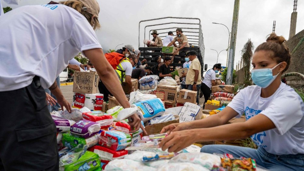 Voluntários distribuem alimentos e itens essenciais em Caraballeda, estado de La Guaira, Venezuela, em 30 de junho de 2026, após os terremotos gêmeos de 24 de junho. Dezenas de milhares de pessoas precisam urgentemente de alimentos e abrigo na Venezuela devido à devastação causada pelos dois grandes terremotos que mataram mais de 1.700 pessoas e feriram 5.000, informou a ONU em 30 de junho, enquanto médicos alertavam para possíveis surtos de doenças. (Foto de Miguel MEDINA / POOL / AFP)