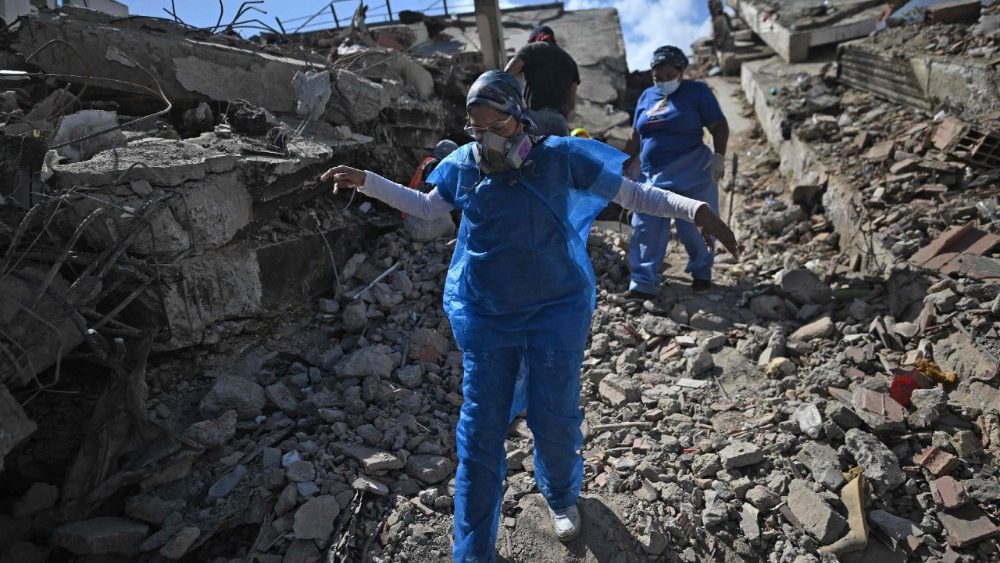 Uma médica legista caminha em meio aos escombros da praia de Los Cocos, em Caraballeda, estado de La Guaira, Venezuela, em 1º de julho de 2026, após os terremotos gêmeos de 24 de junho. Venezuelanos, com ajuda de todo o mundo, ainda buscavam sobreviventes em 1º de julho de 2026, uma semana após os terremotos devastadores que mataram quase 2.000 pessoas e deixaram milhares desaparecidas. (Foto de Juan Barreto / AFP)
