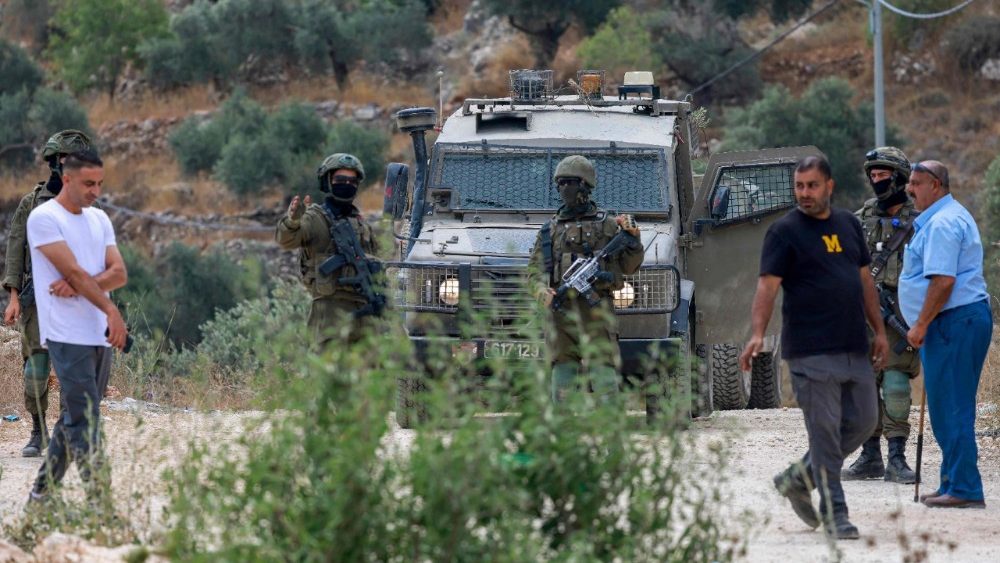 Soldados israelenses impedem palestinos de retornarem às suas casas e terras na vila de Qabalan, ao sul de Nablus, na Cisjordânia ocupada, em 4 de julho de 2026, depois que colonos israelenses, que haviam estabelecido um posto avançado em terras da vila, os impediram de se aproximarem. (Foto de Jaafar ASHTIYEH / AFP)