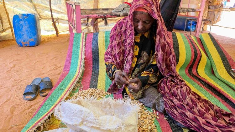 Eine Frau im Sudan, die Bohnen schält