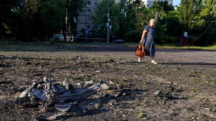 Uma mulher caminha ao lado de um fragmento de m&iacute;ssil em frente a um pr&eacute;dio residencial ap&oacute;s ataques de m&iacute;sseis russos em Kiev, em 19 de julho de 2026, durante a invas&atilde;o russa da Ucr&acirc;nia. M&iacute;sseis russos atingiram a capital ucraniana durante a noite, danificando pr&eacute;dios residenciais e ferindo pelo menos duas pessoas, um dia depois de Kiev ter lan&ccedil;ado uma onda de ataques com drones em territ&oacute;rio russo. (Foto de Serhii Okunev / AFP)