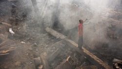 A Palestinian man looks for his belongings amid the debris after an Israeli strike in Gaza City on 24 July