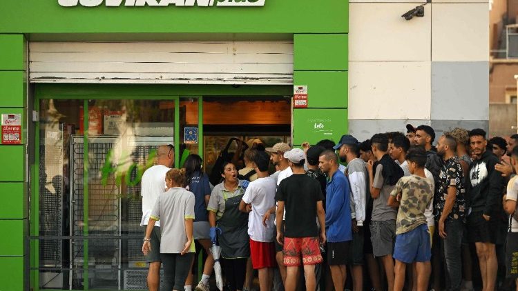 Un gruppo di migranti fuori un supermarket a Ceuta