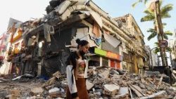 Uma mulher caminha entre os escombros de um prédio que desabou após um terremoto em Pereira, Colômbia, em 11 de agosto de 2026. (Foto de Jaime Saldarriaga / AFP)