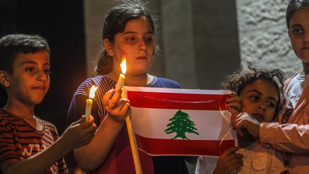 Crianças palestinas seguram vela e bandeira do Líbano (EPA/Mohammed Saber)