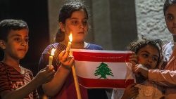 Crianças palestinas seguram vela e bandeira do Líbano (EPA/Mohammed Saber)