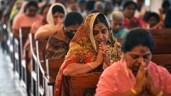 Indian Catholic faithful praying in a church. 