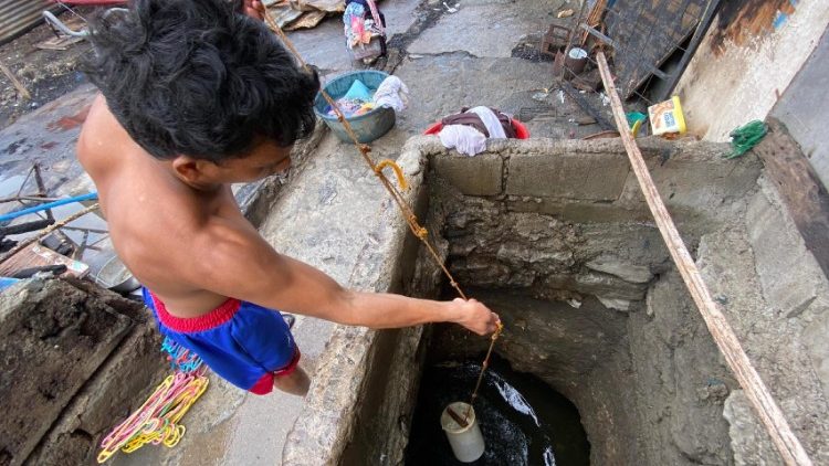 Ein philippinischer Bewohner holt Wasser an einem Brunnen