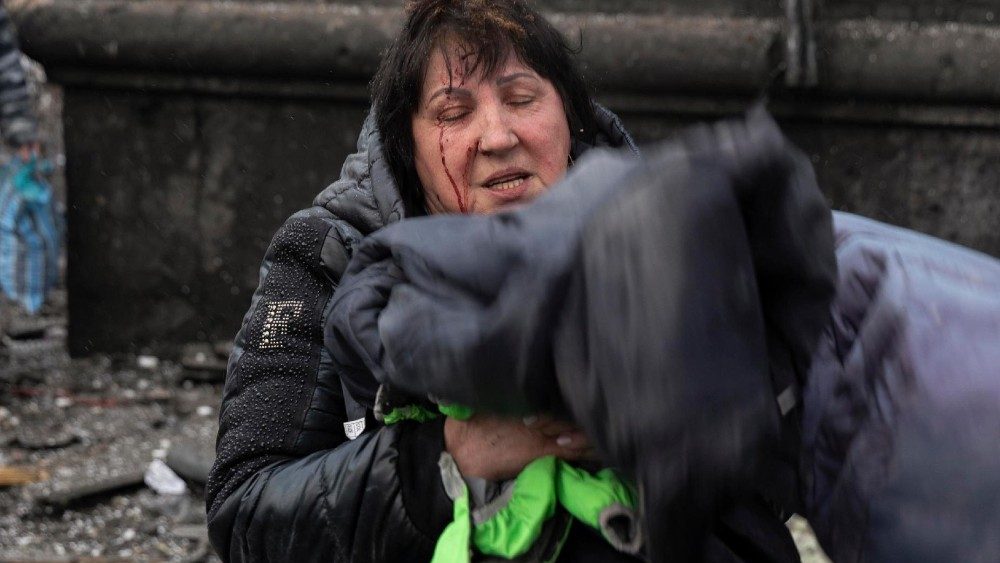 Ucraniana ferida chora no local de um ataque com foguete contra edifício residencial em Kharkiv, nordeste da Ucrânia, em 23 de janeiro de 2024. EPA/YAKIV LIASHENKO