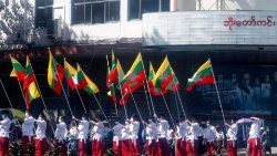 Apoiadores dos militares portam bandeiras no terceiro do golpe. Yangon, 1 de fevereiro de 2024. (EPA/Stringer)