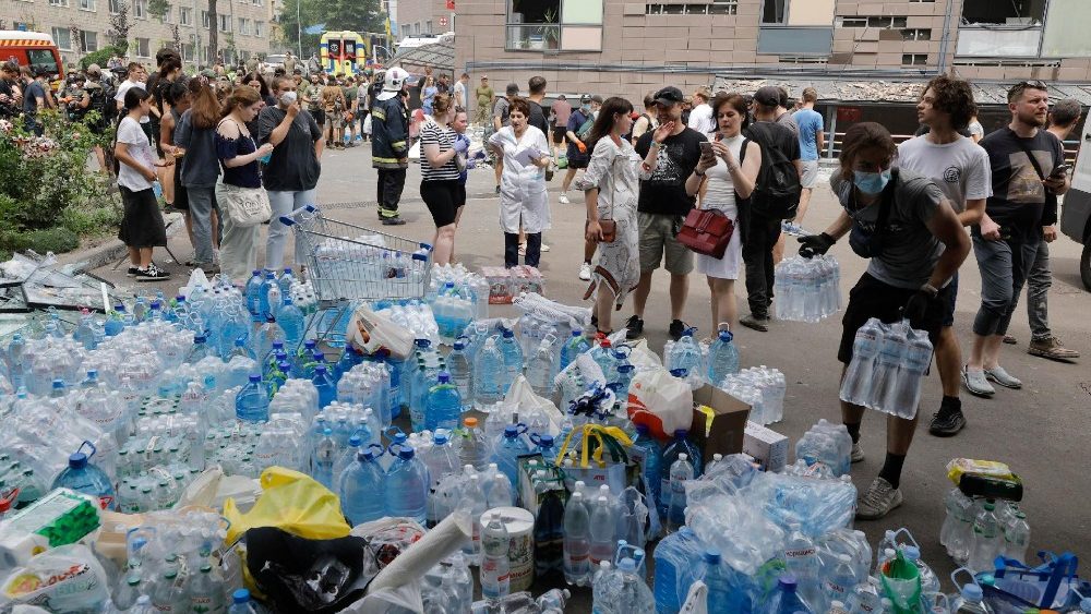 Doações de água no local de um ataque com foguetes ao hospital infantil 'Okhmadyt' em Kiev, Ucrânia, 8 de julho de 2024, em meio à ruína da invasão russa. A Rússia atacou massivamente a Ucrânia com mísseis em 8 de julho, atingindo Kiev, Dnipro, Kryvyi Rih, Sloviansk e Kramatorsk. Foram lançados mais de 40 mísseis de diferentes tipos, atingindo edifícios residenciais, infra-estruturas e o hospital infantil.. EPA/SERGEY DOLZHENK