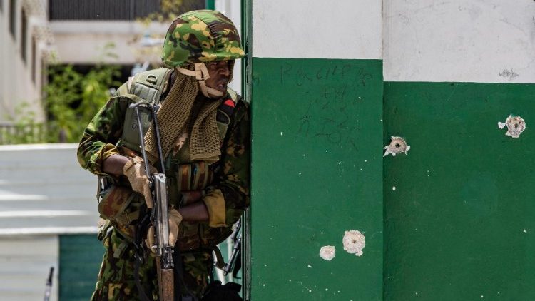 A Kenyan police officer stands guard after a gang attack on the Haitian PM's motorcade in July