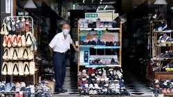 An elderly man stands in a shoe shop in Tokyo