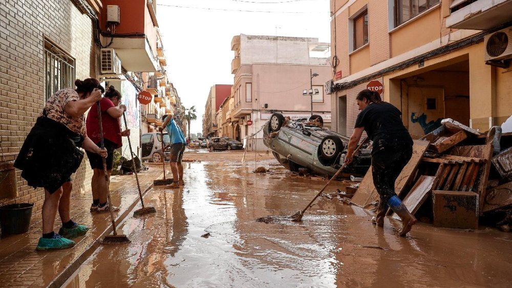 Moradores limpam uma rua coberta de lama no município de Paiporta, atingido por enchentes, na província de Valência, Espanha, em 30 de outubro de 2024. EPA/MANUEL BRUQUE