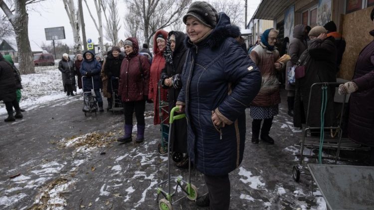 Pessoas ouvem m&uacute;sicos volunt&aacute;rios (n&atilde;o retratados) se apresentando enquanto civis se re&uacute;nem para coletar ajuda alimentar em um ponto de distribui&ccedil;&atilde;o criado pela administra&ccedil;&atilde;o regional, em Pokrovsk, Ucr&acirc;nia, 06 de dezembro de 2024 (emitido em 07 de dezembro de 2024). A cidade de Pokrovsk est&aacute; sitiada por tropas russas desde agosto de 2024, com tropas russas estacionadas a apenas cinco quil&ocirc;metros da cidade. A R&uacute;ssia bombardeou postos de energia e gasolina em setembro, enquanto o fornecimento de &aacute;gua pot&aacute;vel foi cortado, deixando os civis dependendo apenas de ajuda humanit&aacute;ria. EPA/MARIA SENOVILLA