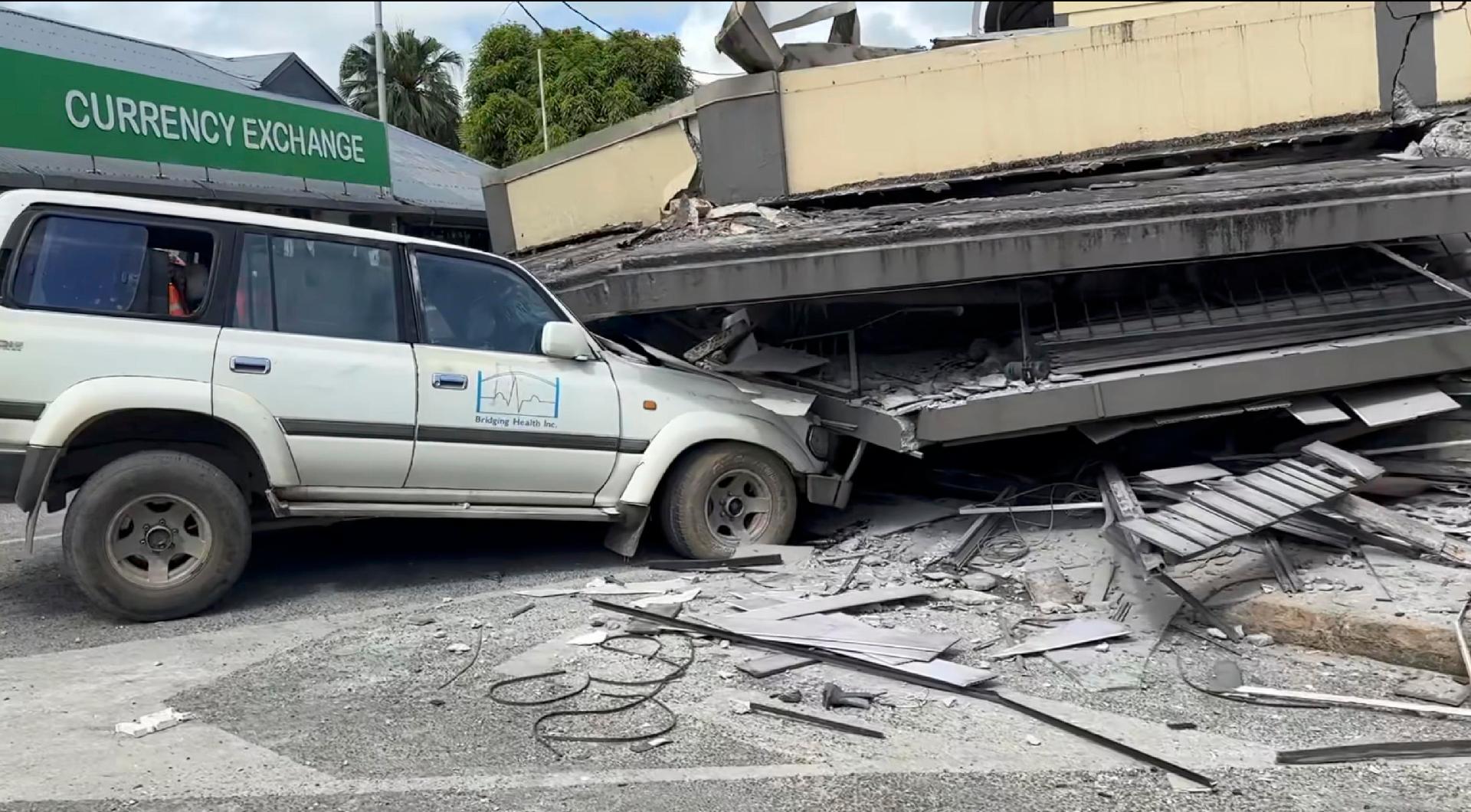 Uma foto de folheto disponibilizada por Michael Thomson mostra uma captura de tela de vídeo de um carro preso sob um prédio desabado após um terremoto em Port Vila, Vanuatu, em 17 de dezembro de 2024. EPA/MICHAEL THOMSON
