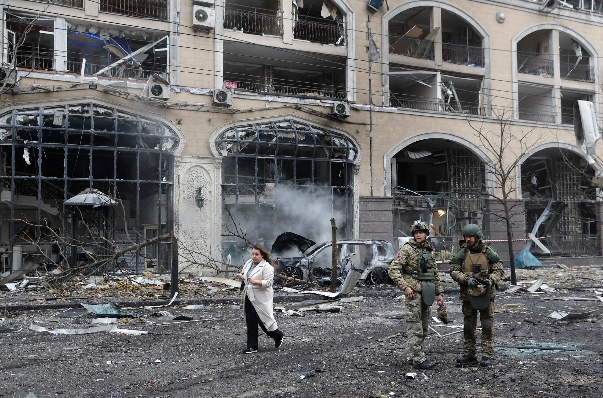 Mulher ucraniana passa por dois policiais perto de um prédio danificado no local de um ataque de míssil no centro de Kiev, Ucrânia, 20 de dezembro de 2024, em meio à invasão russa. Pelo menos uma pessoa foi morta e outras 10 ficaram feridas como resultado do bombardeio russo em Kiev, de acordo com o Serviço de Emergência Estatal da Ucrânia (SESU). EPA/SERGEY DOLZHENKO