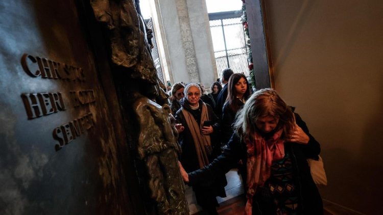 Pereginos pasan la Puerta Santa en la Basílica de San Juan de Letrán, inaugurada el domingo 29 de diciembre de 2024. (ANSA)