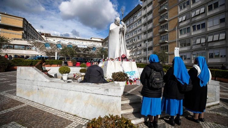 Religiosas rezan ante la imagen de San Juan Pablo II en el Hospital Gemelli por la pronta recuperación del Papa. (ANSA)
