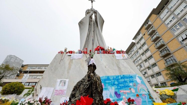 ഫ്രാൻസീസ് പാപ്പാ ചികിത്സയിൽ കഴിയുന്ന റോമിലെ ജെമേല്ലി ആശുപത്രിയുടെ മുൻവശം, അവിടെ സ്ഥാപിച്ചിട്ടുള്ള വിശുദ്ധ രണ്ടാം ജോൺ പോൾ മാർപ്പാപ്പായുടെ പ്രതിമയോടുകൂടിയ ദൃശ്യം