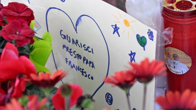 Ob kipu sv. Janeza Pavla II., ki stoji pred bolnišnico Gemelli, ljudje puščajo cvetje, sveče, risbe in sporočila z željami za hitro okrepanje papeža Frančiška.
