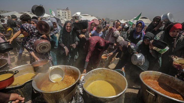 உணவைப் பெறக் காத்திருக்கும் புலம்பெயர்ந்த காசா மக்கள்