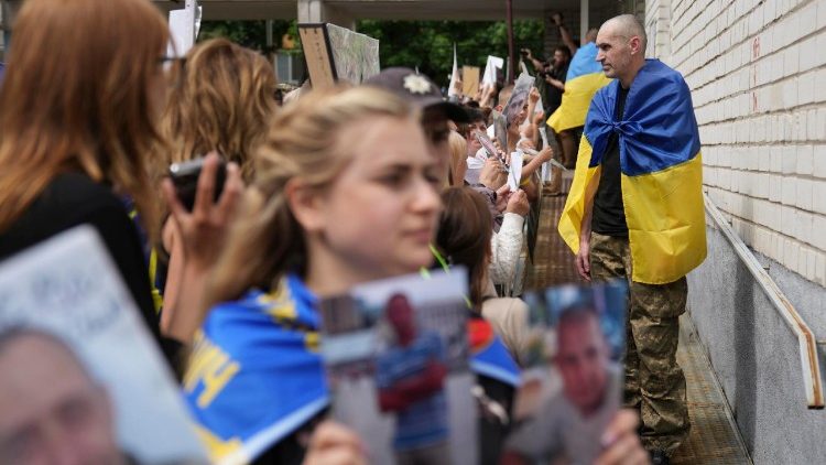 Ukrainian women hold photos of their missing relatives