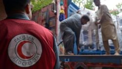 Volunteers from the International Red Crescent Societies (IFRC) loads relief goods for people who were affected by flooding from monsoon rains in the Khyber Pakhtunkhwa province
