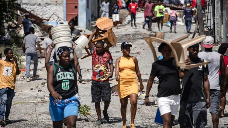 Persone sfollate camminano tra le strade di Port-au-Prince