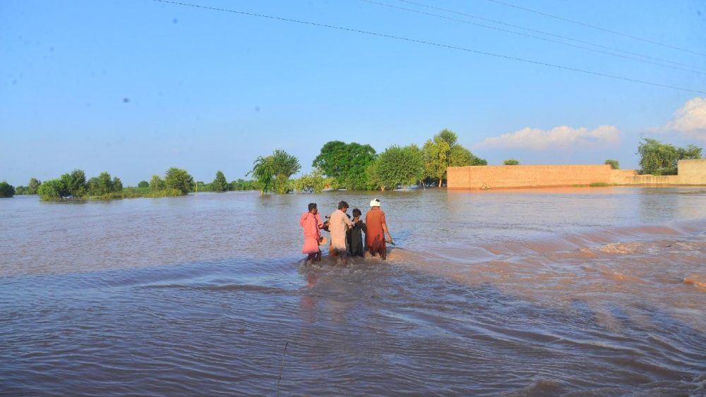 Pessoas atravessam uma área inundada após a elevação das águas do rio Ravi, em Tandlianwala, província de Punjab, Paquistão, em 1º de setembro de 2025. Pelo menos 33 pessoas morreram e mais de 1,4 milhão foram afetadas no Paquistão.