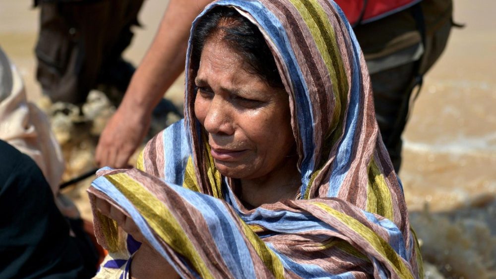 Uma mulher reza enquanto pessoas caminham por uma rua inundada durante fortes chuvas de monções nos arredores de Peshawar, na província de Khyber Pakhtunkhwa (KPK), Paquistão, em 2 de setembro de 2025. De acordo com a Autoridade Nacional de Gestão de Desastres (NDMA) do Paquistão, pelo menos 488 pessoas morreram e outras 359 ficaram feridas devido às chuvas de monções na província de Khyber Pakhtunkhwa desde 26 de junho. EPA/BILAWAL ARBAB