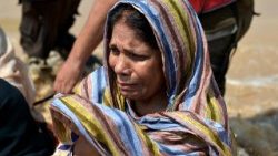 Uma mulher reza enquanto pessoas caminham por uma rua inundada durante fortes chuvas de monções nos arredores de Peshawar, na província de Khyber Pakhtunkhwa (KPK), Paquistão, em 2 de setembro de 2025. De acordo com a Autoridade Nacional de Gestão de Desastres (NDMA) do Paquistão, pelo menos 488 pessoas morreram e outras 359 ficaram feridas devido às chuvas de monções na província de Khyber Pakhtunkhwa desde 26 de junho. EPA/BILAWAL ARBAB