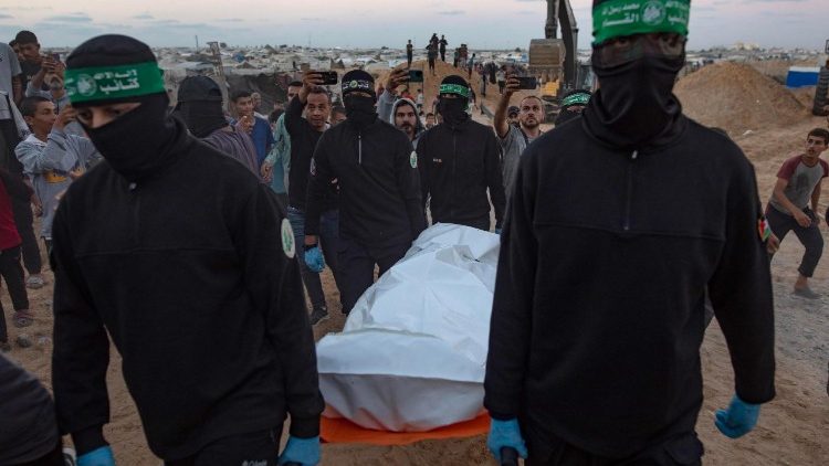 Miliziani di Hamas nella Striscia di Gaza trasportano i resti della salma di uno degli ostaggi da restituire a Israele nell'ambito dell'accordo di cessate il fuoco