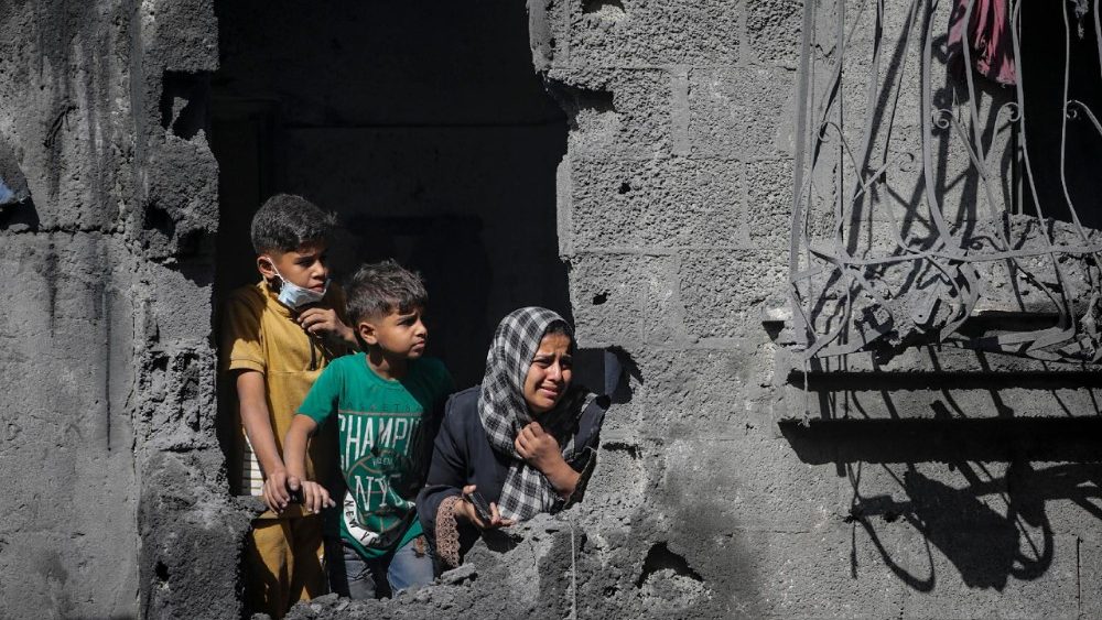 Crianças palestinas observam a destruição da casa de sua família após um ataque aéreo israelense contra um bloco residencial no campo de refugiados de Al Shatea, na Cidade de Gaza. (EPA/MOHAMMED SABER)