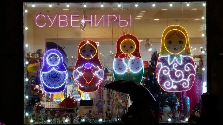 Pessoas caminham em frente a uma loja de souvenirs decorada com imagens iluminadas de bonecas Matryoshka russas no centro de São Petersburgo, Rússia, em 29 de novembro de 2025. EPA/ANATOLY MALTSEV