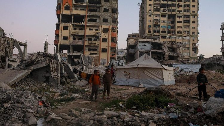 Bambini palestinesi sfollati giocano tra le rovine di edifici distrutti nel quartiere di Al Remal a Gaza City (Epa/Mohammed Saber)