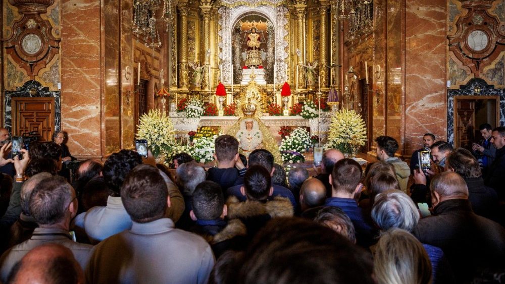 Fiéis rezam diante da Virgem de Macarena em seu retorno à Basílica de Sevilha, na Espanha, em 8 de dezembro de 2025, após quatro meses de extensa restauração estrutural. EPA/JULIO MUNOZ