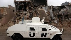  Un mezzo dell'Unifil accanto a un edificio distrutto nel sud del Libano