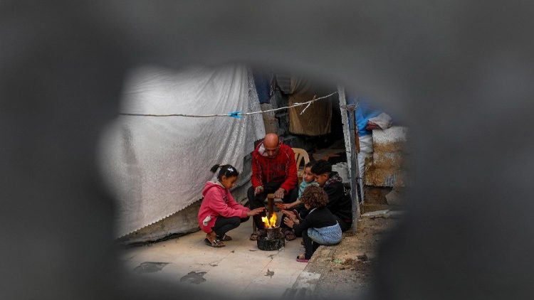 Displaced Palestinian families shelter among the ruins of their homes