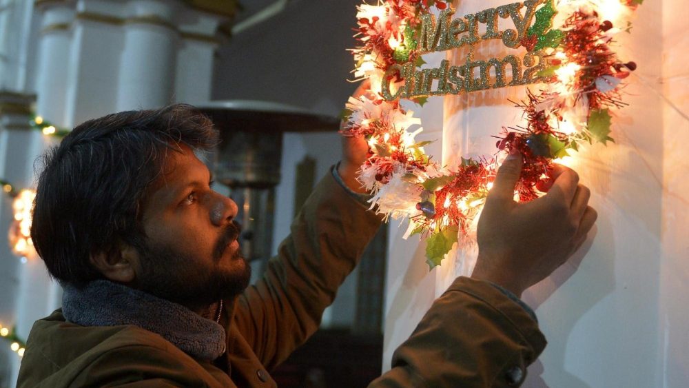 Um cristão paquistanês instala decorações natalinas dentro da Catedral de São João, em Peshawar, Paquistão, em 23 de dezembro de 2025. EPA/BILAWAL ARBAB