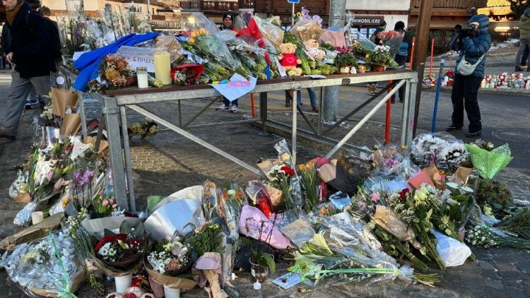 Maua na ujumbe mbele ya bara iliyoungua moto huko Grans Montana nchini Uswiss.